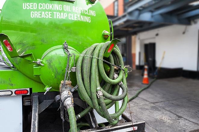 a technician pumping a grease trap in a commercial building in Millstadt, IL